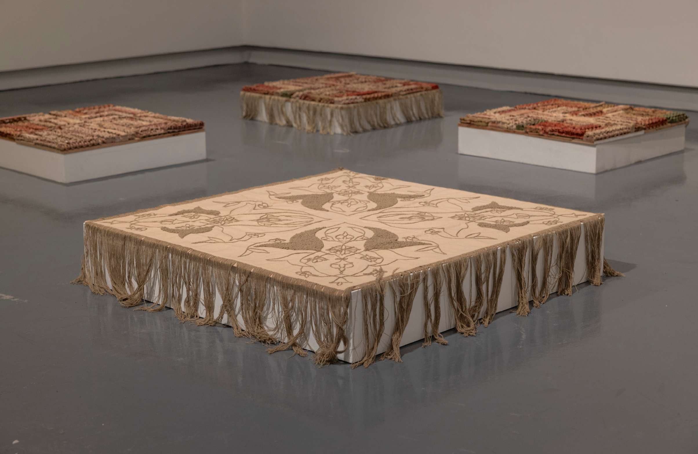 Central textile element with tassels surrounded by ceramic fields